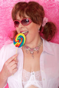 In pigtails, licking lollipop
